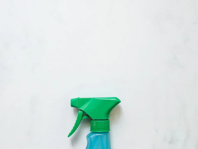 Flacon spray bleu sur fond blanc — solution acide citrique détartrant