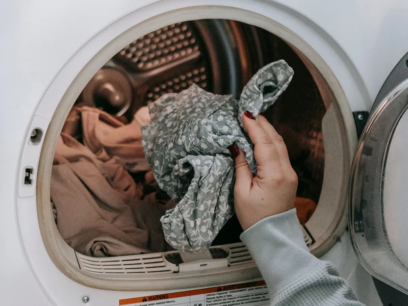 femme effectuant l’entretien régulier de son lave-linge à domicile, routine de maintenance préventive
