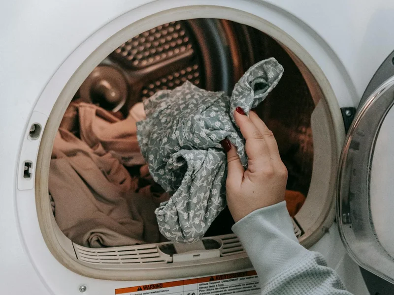 Femme chargeant du linge dans un lave-linge moderne — entretien lave-linge