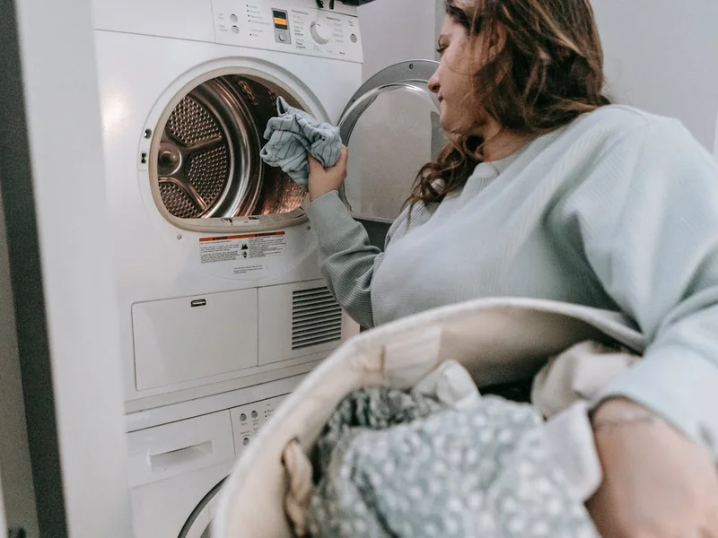 Main versant du produit dans le tambour d’un lave-linge — nettoyage profond