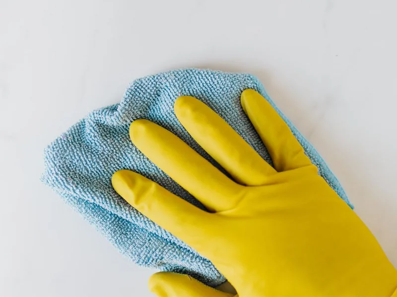 Mains gantées nettoyant un filtre sous l&rsquo;eau
