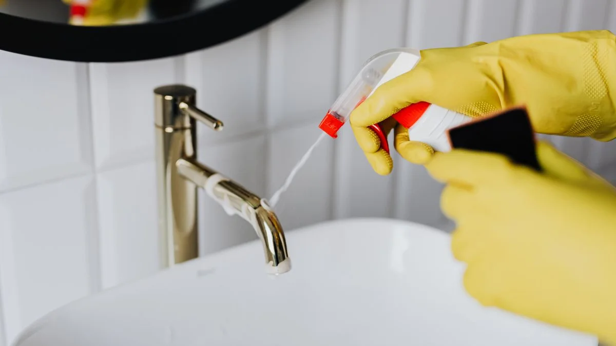 Cuillère doseuse de poudre blanche de percarbonate de soude à côté de linge blanc propre plié