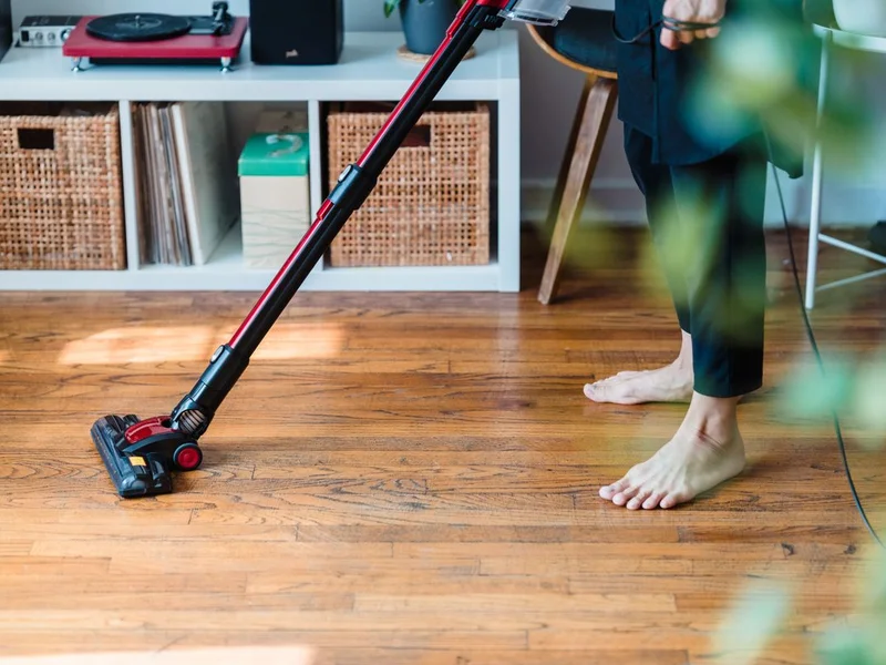 Gros plan balai-brosse nettoyant une lame de terrasse bois avec mousse de savon noir