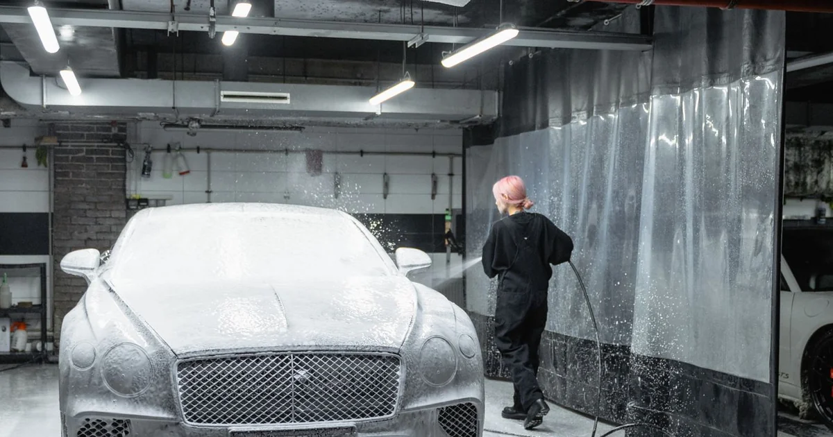 Lavage de la carrosserie d'une voiture avec du savon noir dilué et un gant microfibre